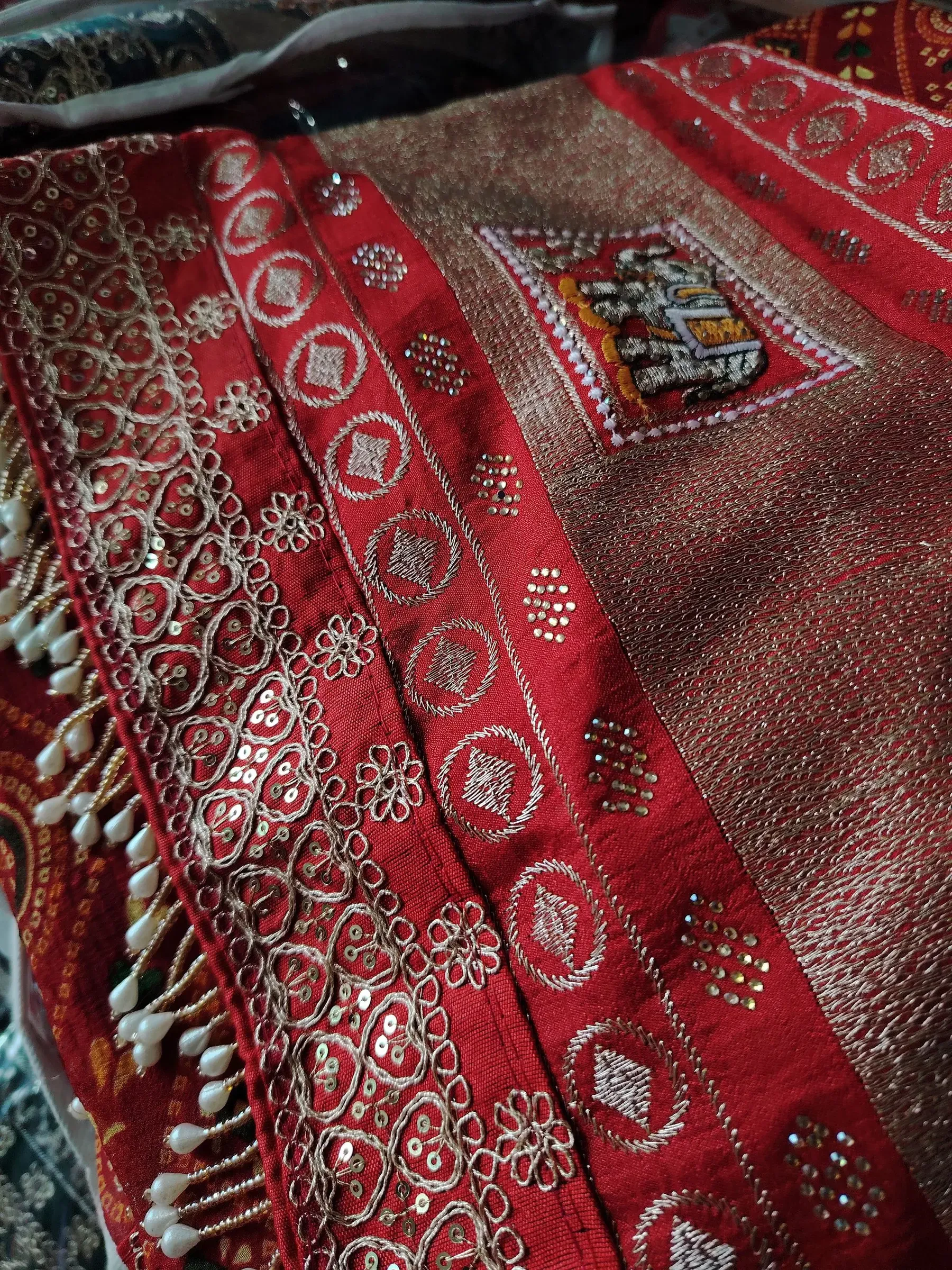 Dense red embroidery with small mirrors, close up