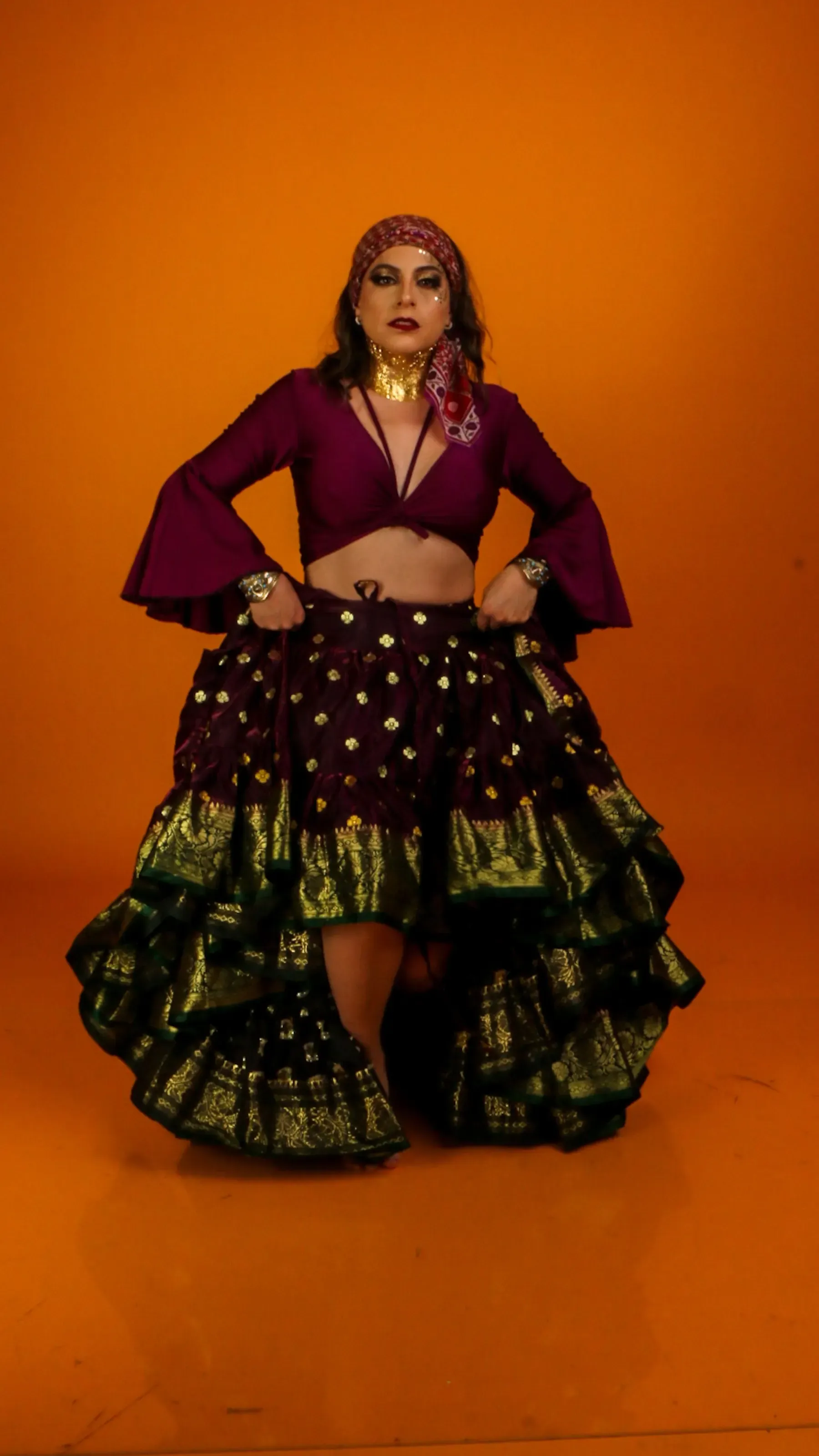 Model in the Raatrani ruffle ghagra set against an orange wall